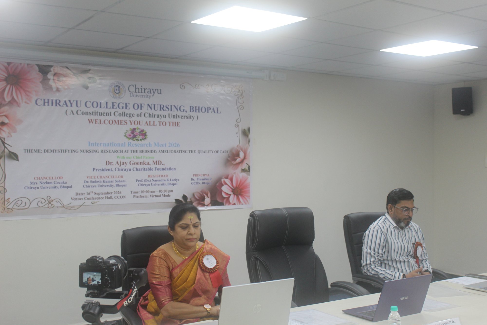 Dignitaries seated before the conference banner